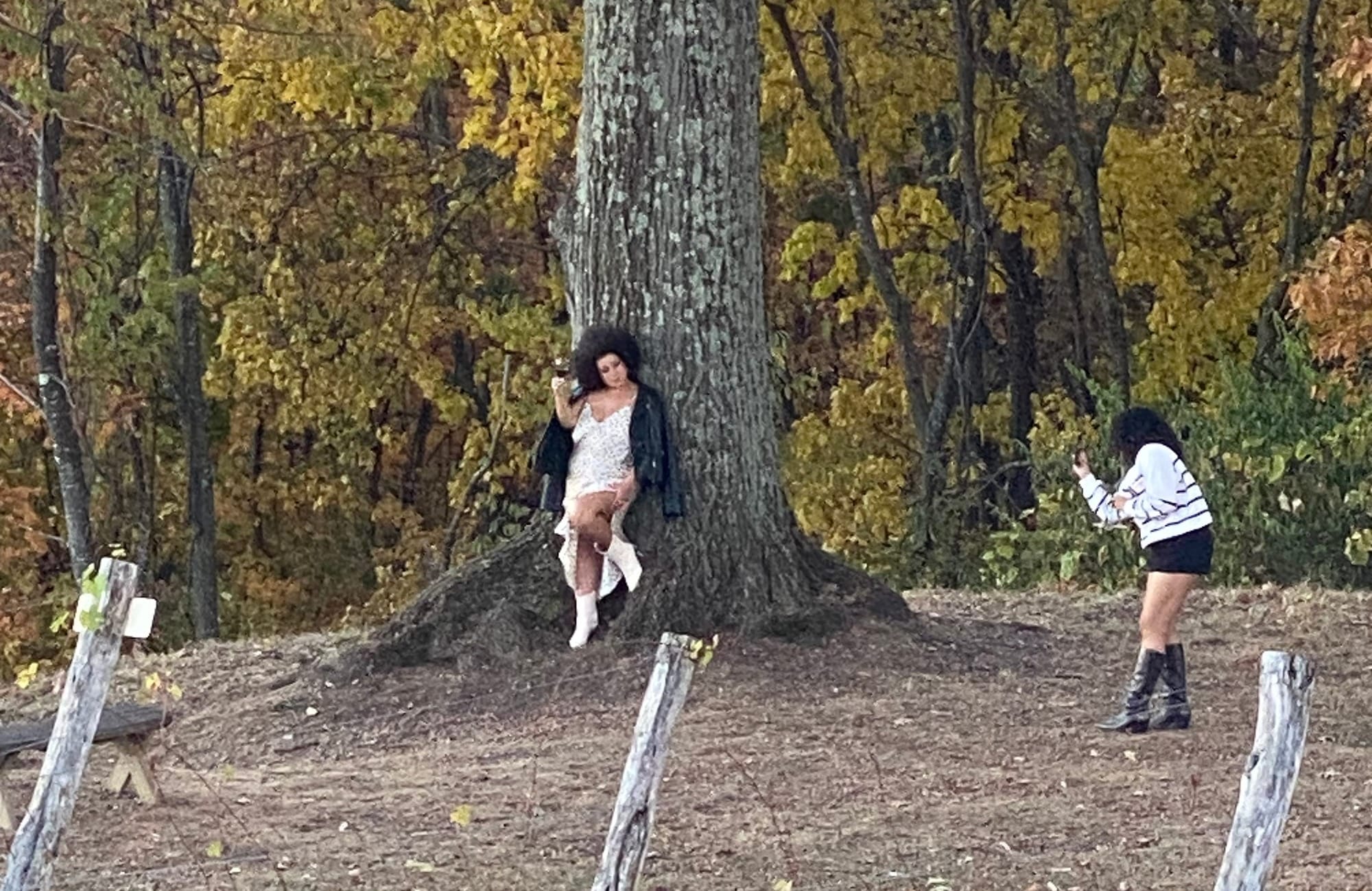 A woman posing for an over-the-top photo at the winery while her friend dutifully captures every angle
