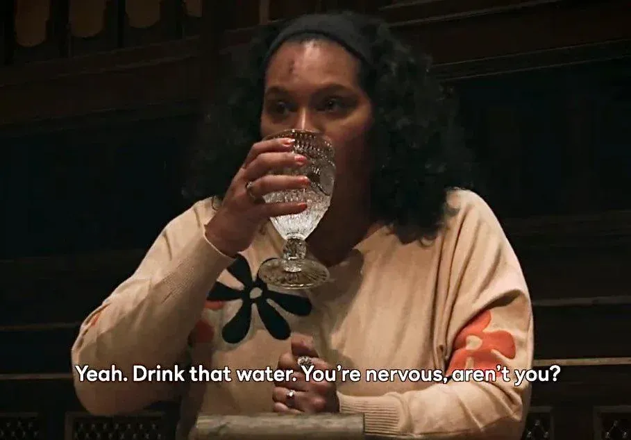 A screenshot of Sandra-Diaz Twine drinking a glass of water on the Traitors season 3, while Janelle PIerzina taunts her, “Yeah, drink that water, you’re nervous, aren’t you?”