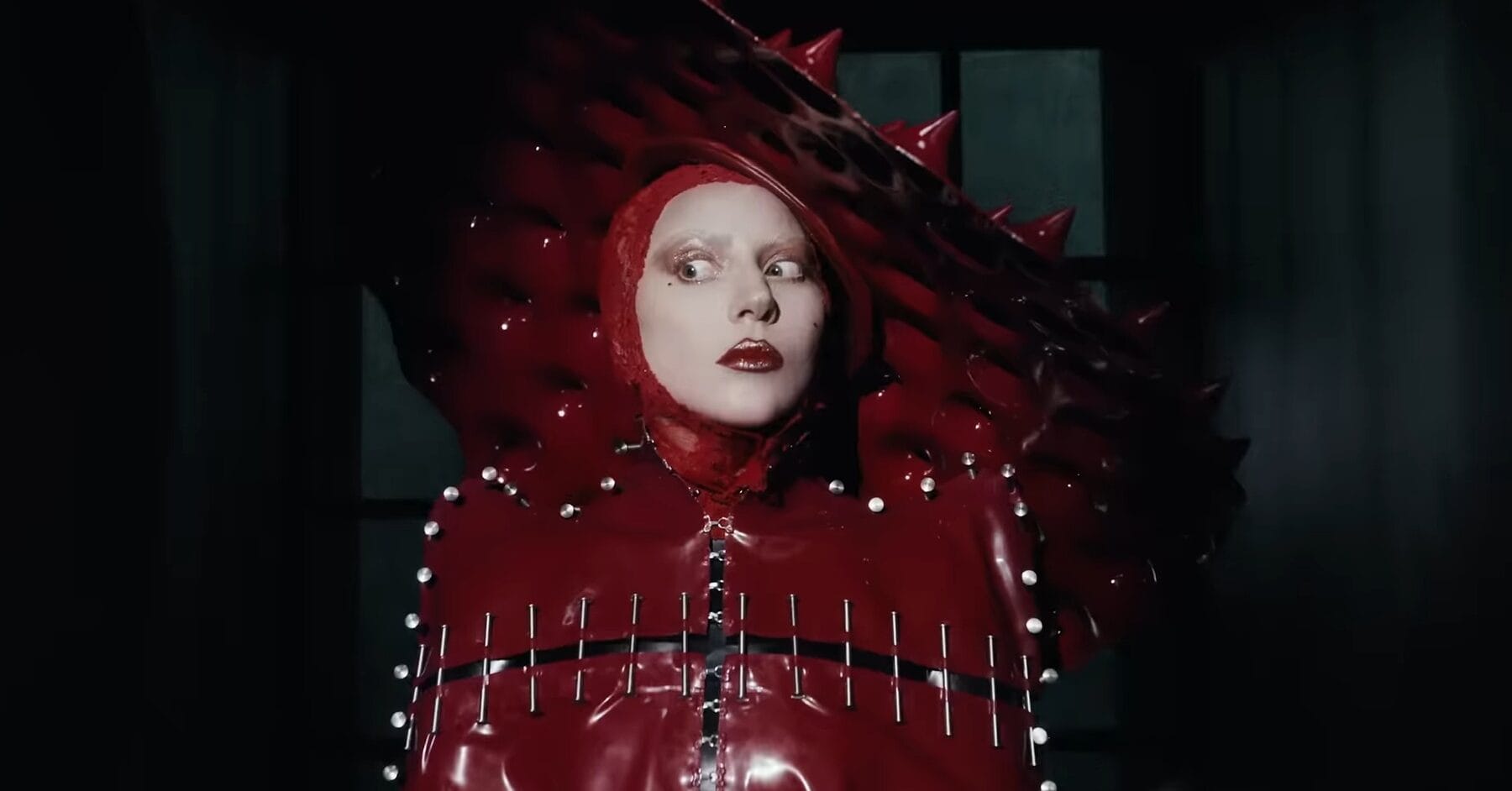 A still of Lady Gaga looking insane in her red look from the Abracadabra music video