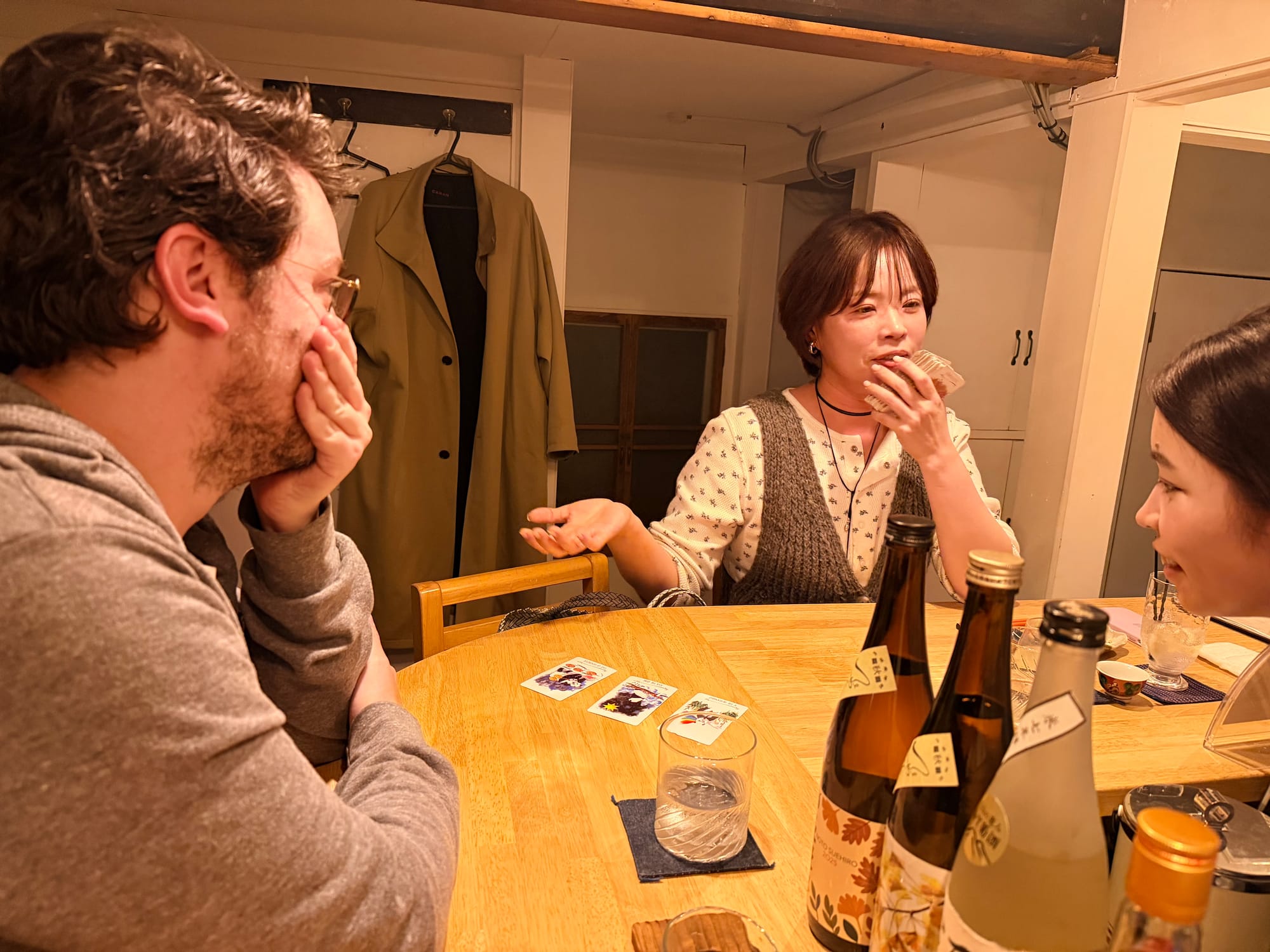 Me, sitting at a bar, while Maki, a young Japanese woman, reads my tarot. She's gesturing to the cards, explaining them, while I cover my mouth, shocked